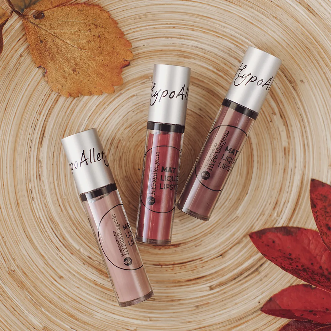 Bell HYPOAllergenic liquid lipstick bottles on wooden coaster